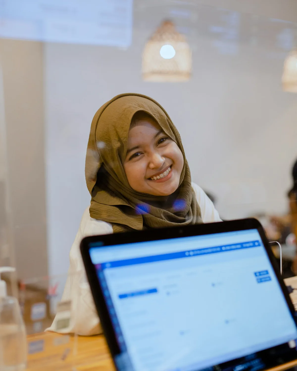 A smiling woman entrepreneur working on her laptop